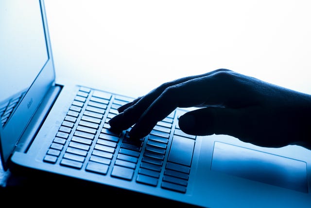 A person's hand on a laptop keyboard