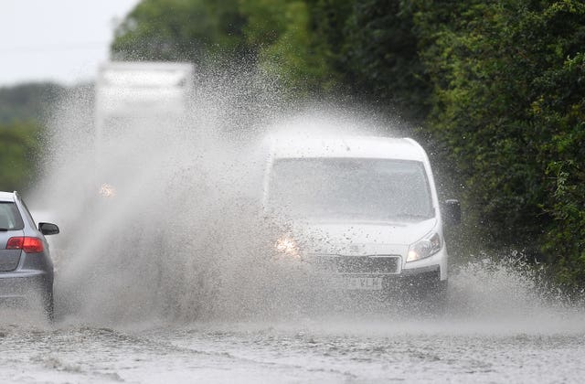 Cars make their way through standing water on the A47 near Peterborough