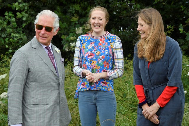 The Prince of Wales speaks with beekeepers Tanya Hawkes (right) and her daughter Esme during his visit to FarmED