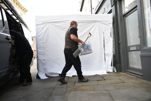 Contractors unload equipment into the Clean Plate cafe in Southgate Street, Gloucester as excavation work for missing Mary Bastholm got underway (Ben Birchall/PA)