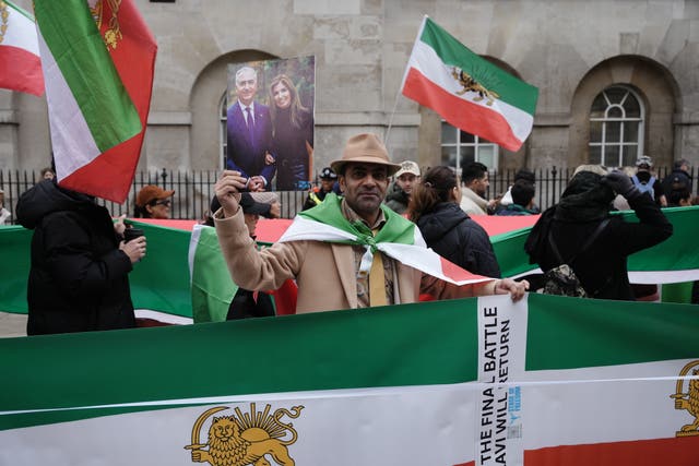 People hold Iranian flags while on a protest march