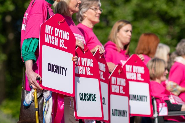 People with terminal illnesses, surrounded by loved ones, display their dying wishes on tags outside Westminster