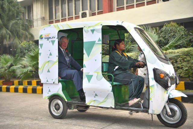 The Prince of Wales is given a demonstration of an e-rickshaw at the Indian MET office in New Delhi