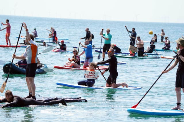 People take part in a paddle-out protest in Brighton