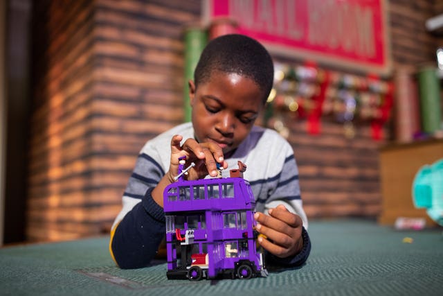 Peter Olunloyo, eight, plays with a Harry Potter Knight bus toy by Lego