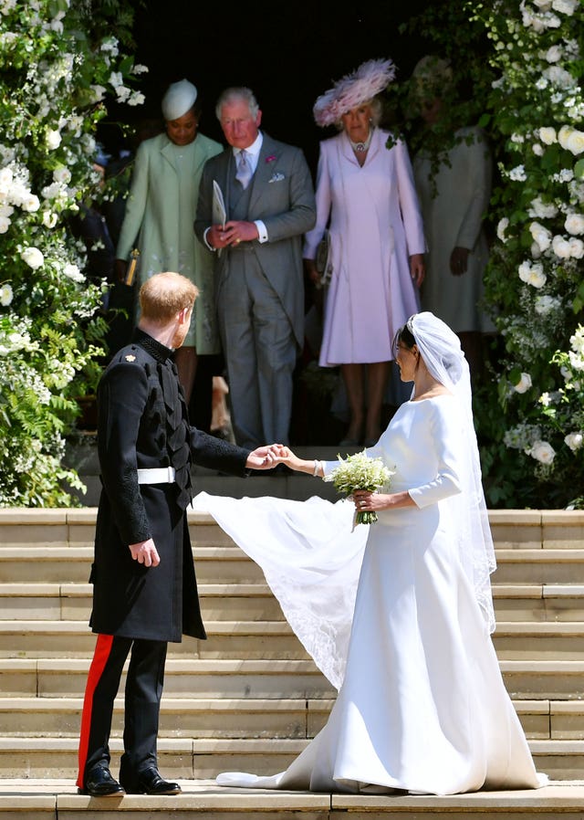 Harry and his wife Meghan turn to watch Doria Ragland, the Prince of Wales and the Duchess of Cornwall as they walk down the west steps of St George’s Chapel, Windsor Castle (Ben Stansall/PA)