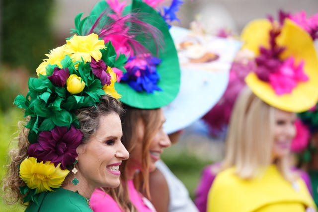 A woman wears a hat that looks like a bunch of flowers
