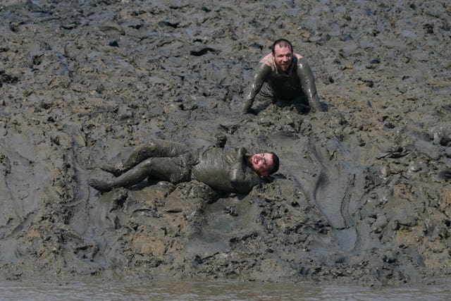 Two men sprawled in mud