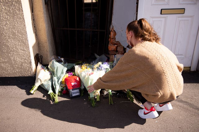 A woman leaves flowers at the scene on High Street, Brownhills 