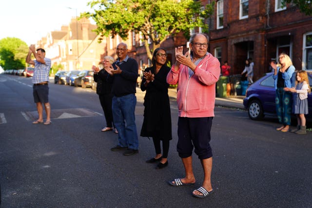 Neighbours of Annemarie Plas, 36, a Dutch national living in south London who created the weekly 8pm Clap For Our Carers, in south London joining the applause (Aaron Chown/PA)