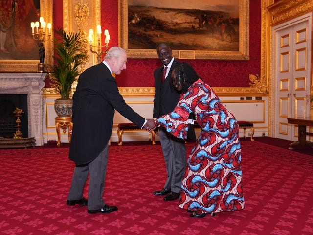 Christine Asoma, accompanying Maurice Makoloo, clasps the King's hand during the audience 
