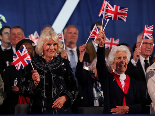 The Queen and Mavis Bensley wave flags during the VE Day concert