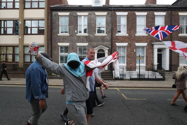 Three men walk in a street draped in union flags