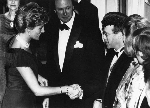 Diana, Princess of Wales being greeted by Sir Elton John at a charity premiere in 1991 (PA)