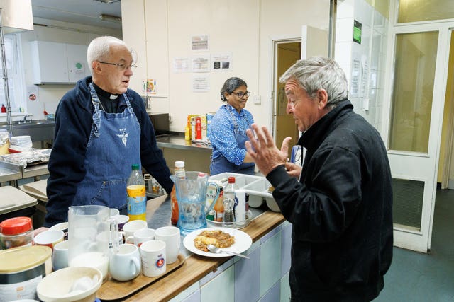 Archbishop of Canterbury Justin Welby, left, serving lunch during the Big Help Out