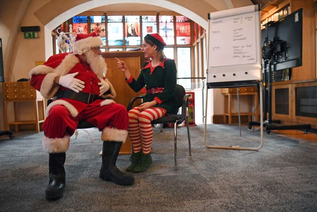 A Father Christmas performer talks to an Elf