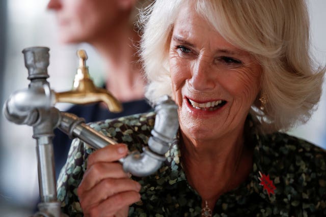 Camilla holds a tap given to her by plumber Khawla Al-Sheikh