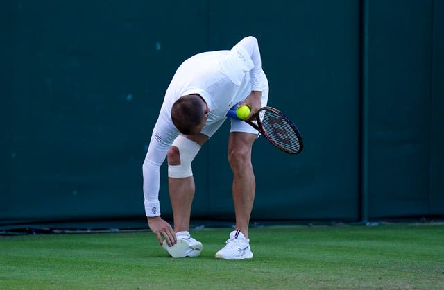 Dan Evans inspects the bottom of his trainer 
