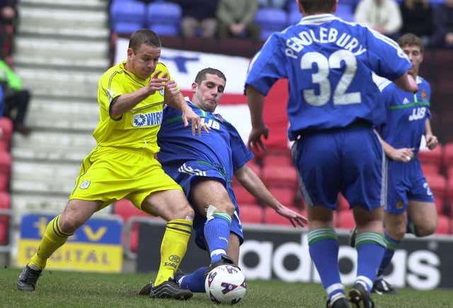 Wigan's Paul Mitchell slide tackles Tranmere's Nick Henry