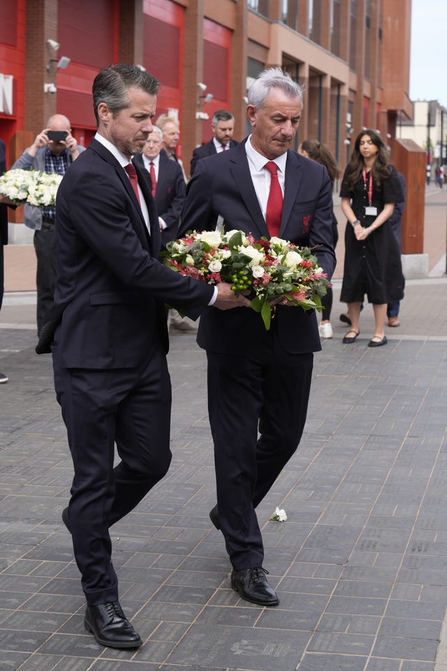 Liverpool chief executive Billy Hogan and former striker Ian Rush carry a wreath 