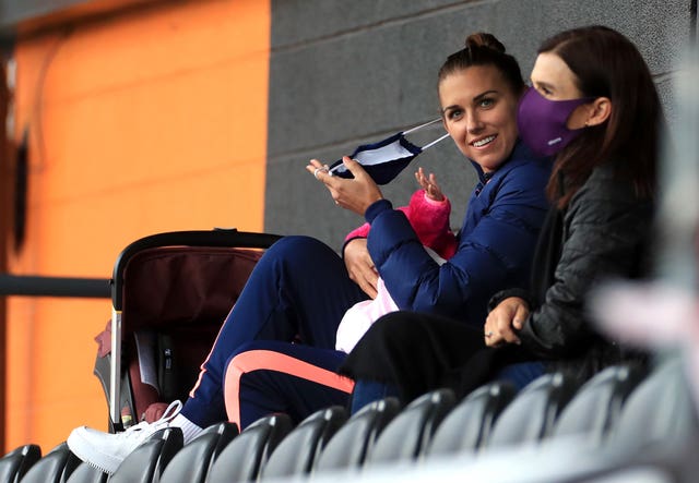 Alex Morgan, left, watches Tottenham Hotspur Women play London City Lionesses with baby daughter Charlie at the Hive