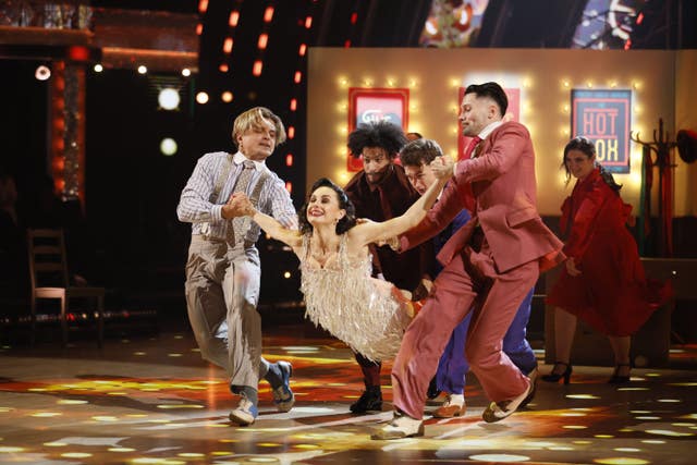 Amber Davies being held above the ground by Nikita Kuzmin and other dancers