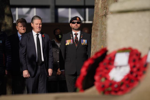 Labour leader Sir Keir Starmer, left, observes a two-minute silence at the war memorial at Euston Station in London, after laying a wreath, to remember the war dead on Armistice Day