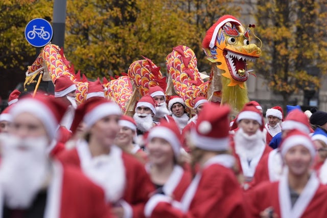 A Chinese dragon dances behind Santa runners 