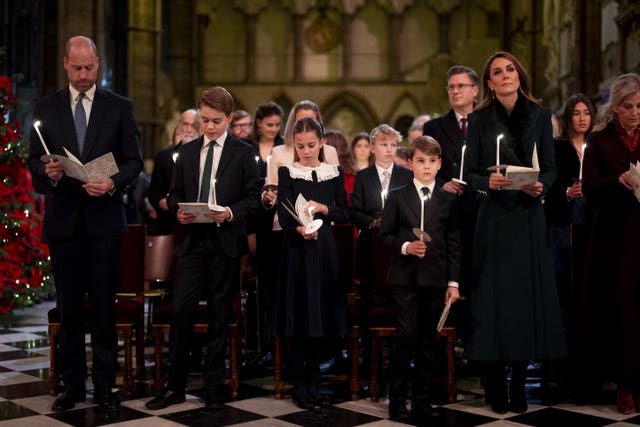 William and Kate with their children holding candles during the Together At Christmas carol service at Westminster Abbey