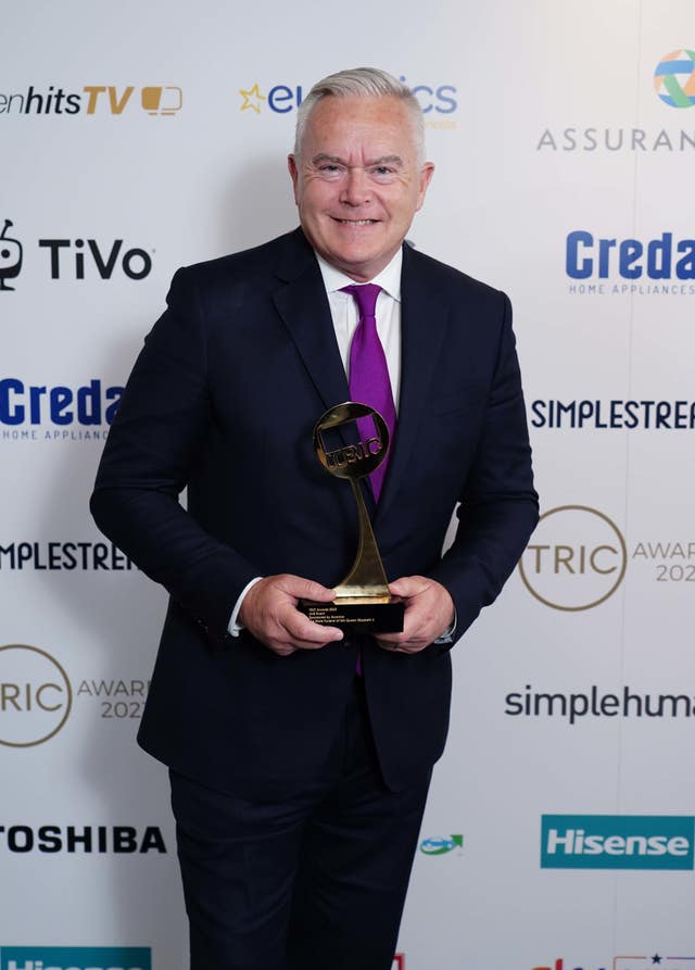 Huw Edwards holding an award