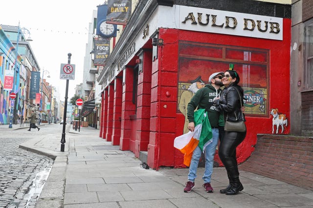 Anderson Lima and Julianna Santos, originally from Brazil but living in Ireland, celebrate St Patrick’s Day on a quiet Temple Street in Dublin (Brian Lawless/PA)