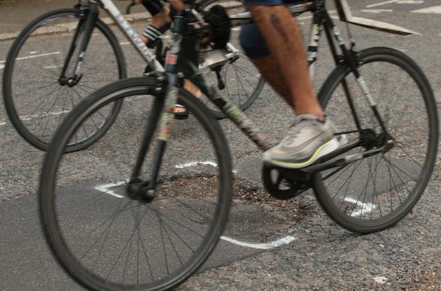 Cyclists riding past a pothole in Islington, London