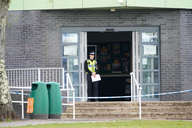 A police officer stands at the entrance to the school in Ammanford