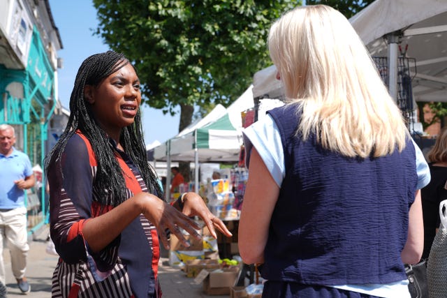 Kemi Badenoch speaks to a woman on a street in Epping