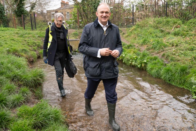 Leader of the Liberal Democrats Ed Davey helps to clear rubbish from the River Wandle in south west London