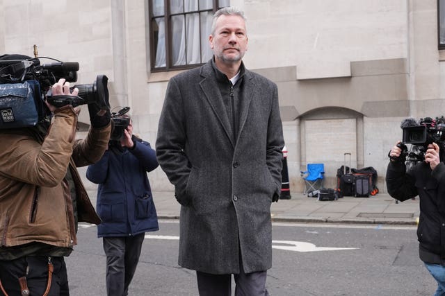 Photographers and camera operators surround Nathan Gill as he leaves the Old Bailey