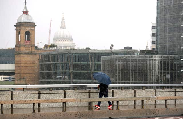 A person walking in the snow on London Bridge (Steve Parsons/PA)