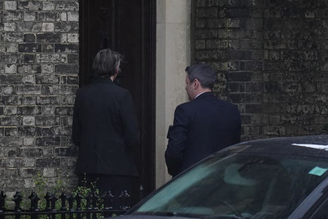Two people wait to enter a property