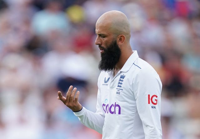 Moeen Ali inspects his injured index finger.