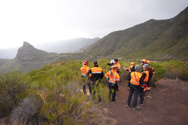 Search teams look through the hills near the village of Masca