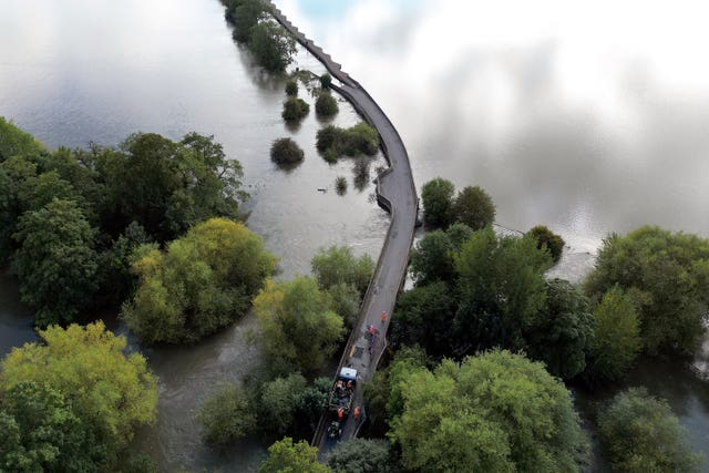 Workers close Carlton Road in Harrold, Bedfordshire, due to flooding after the River Great Ouse burst its banks