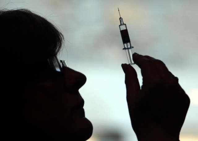 A nurse prepares a vaccine