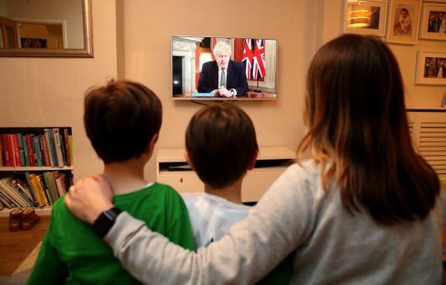 A family in Knutsford, Cheshire, watch Prime Minister Boris Johnson making a televised addres