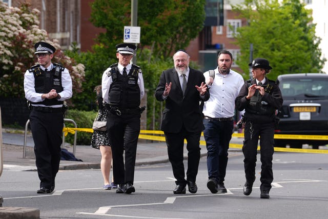 Sir Ephraim Mirvis, centre, at the scene in Golders Green on Wednesday