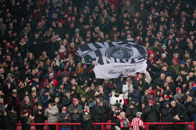 Fans hold up a banners inside the stadium