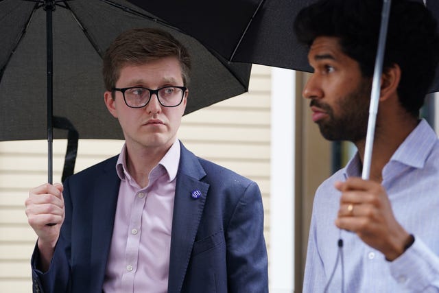 Dr Robert Laurenson and Vivek Trivedi, co-chairs of the junior doctors committee, holding umbrellas