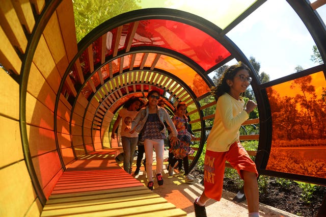 Children running through a light tunnel in the garden 