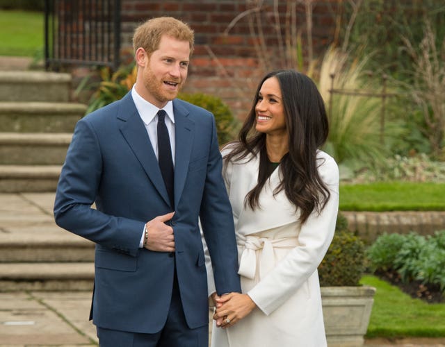 Meghan holds Harry's arm