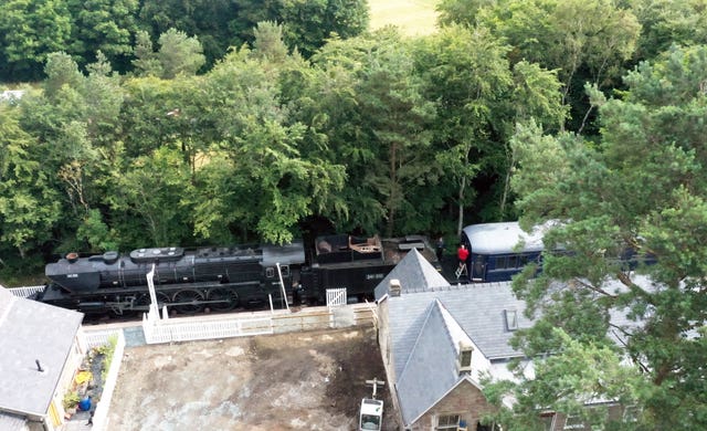 A full-size steam train with carriages, tracks and platform as Simon and Diana Parums converted and restored Bassenthwaite Lake station in Keswick