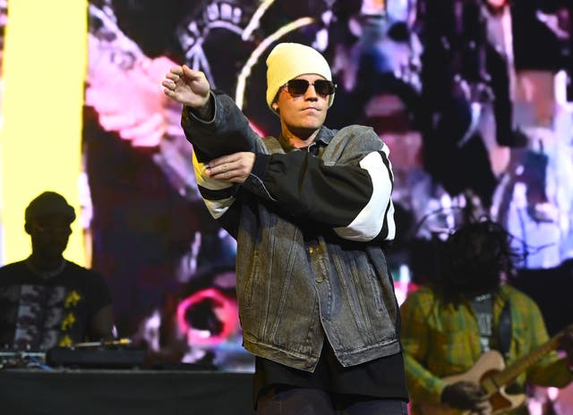 Justin Bieber on stage wearing a jacket and white beanie holding a microphone at Capital’s Jingle Bell Ball 2021.